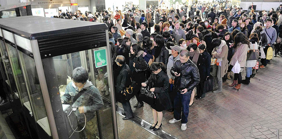 People line up in front of public telephone booths at Shibuya station in Tokyo March 11, 2011. The biggest earthquake to hit Japan since records began 140 years ago struck the northeast coast on Friday, triggering a 10-metre tsunami that swept away everything in its path, including houses, ships, cars and farm buildings on fire. REUTERS/YOMIURI(JAPAN - Tags: DISASTER) FOR EDITORIAL USE ONLY. NOT FOR SALE FOR MARKETING OR ADVERTISING CAMPAIGNS. JAPAN OUT. NO COMMERCIAL OR EDITORIAL SALES IN JAPAN. YES